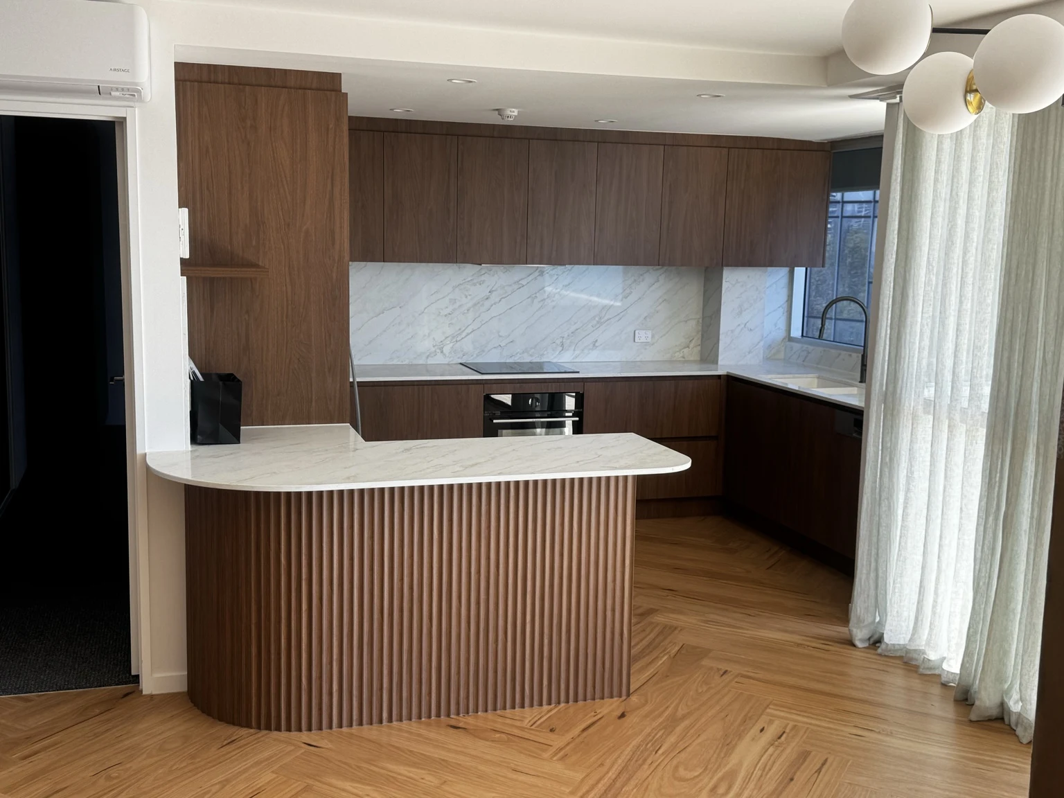 Timber kitchen with a fluted island and herringbone floor