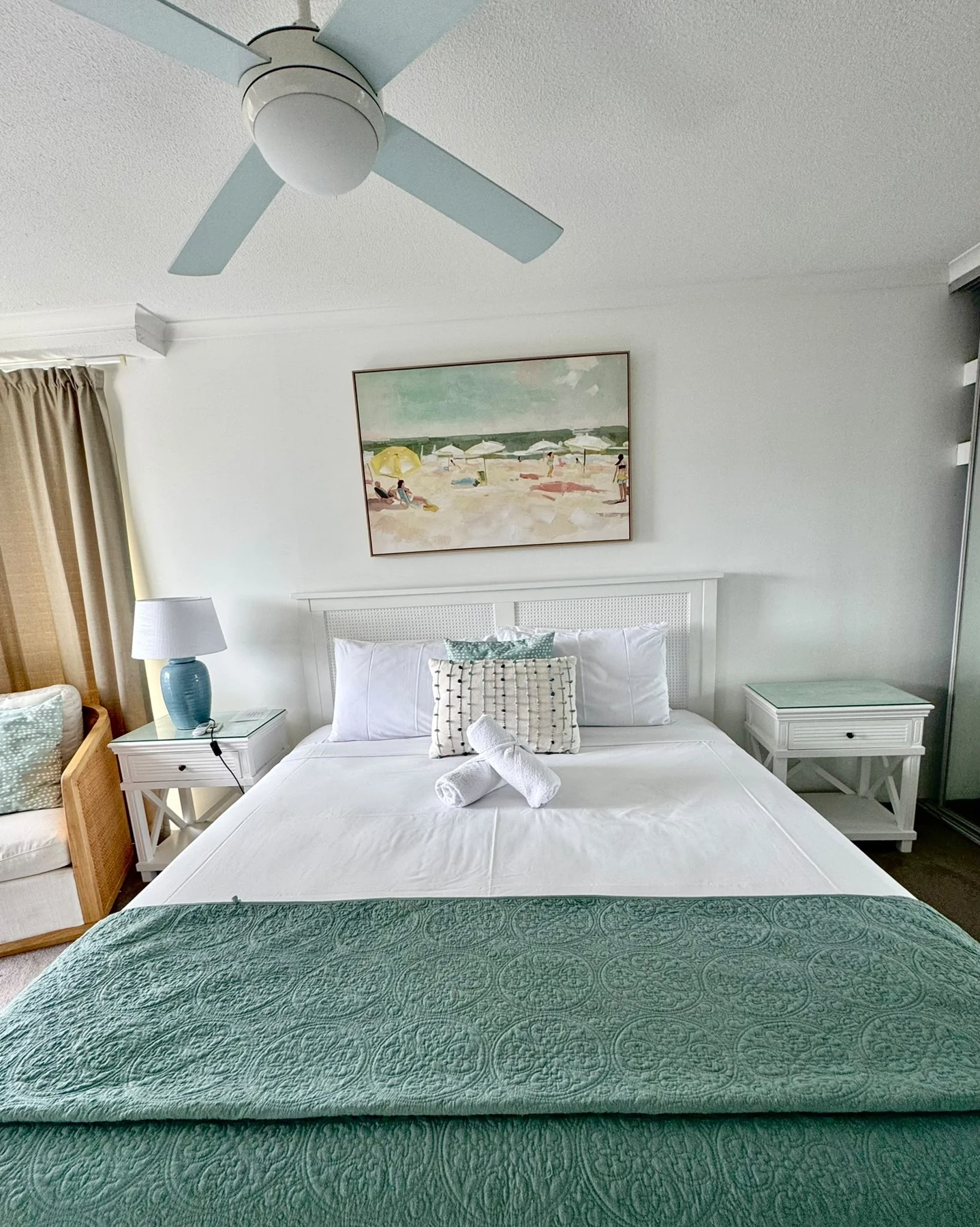 Bedroom with green bedding and folded towels